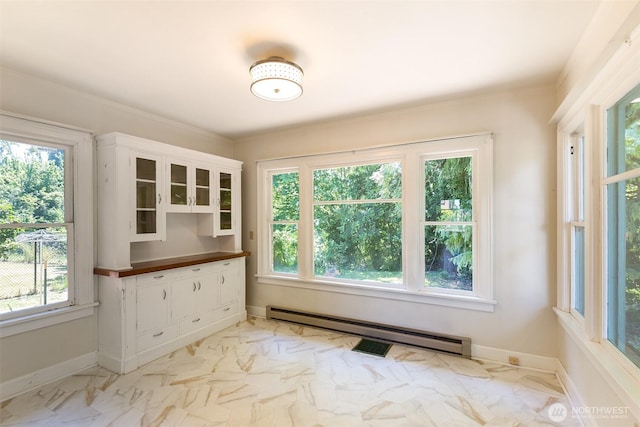 314 E 2nd St, Port Angeles, WA 98362 - unfurnished dining area with a baseboard radiator, light marble finish flooring, and ornamental molding