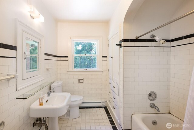 314 E 2nd St, Port Angeles, WA 98362 - full bathroom with tile walls, shower / tub combination, tile patterned flooring, baseboard heating, and wainscoting