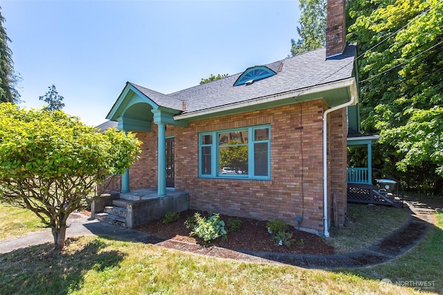 314 E 2nd St, Port Angeles, WA 98362 - view of side of property featuring brick siding, a chimney, a shingled roof, and a yard
