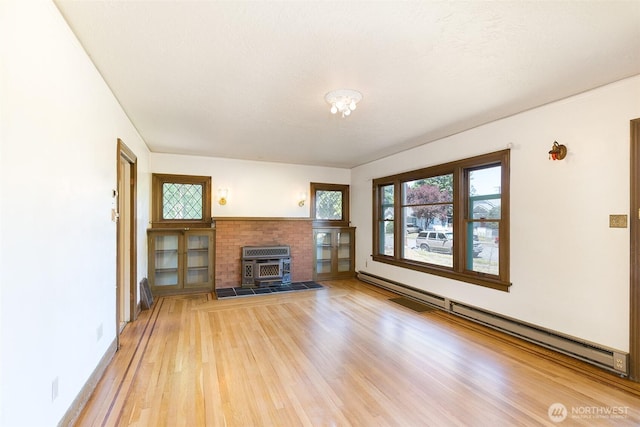 314 E 2nd St, Port Angeles, WA 98362 - unfurnished living room with baseboard heating and light wood-style flooring