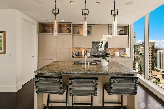 1521 2nd Ave Unit 3801, Seattle, WA 98101 - kitchen featuring tasteful backsplash, dark stone counters, a breakfast bar area, dark wood finished floors, and a kitchen island with sink