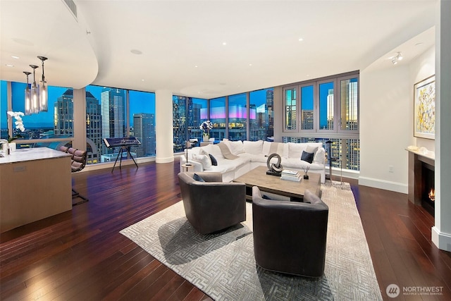 1521 2nd Ave Unit 3801, Seattle, WA 98101 - living area with hardwood / wood-style floors, a warm lit fireplace, a chandelier, and a skyline view