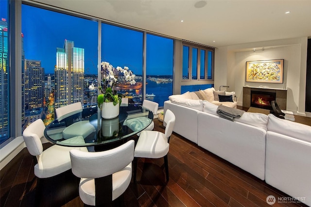 1521 2nd Ave Unit 3801, Seattle, WA 98101 - dining space featuring wood finished floors, a glass covered fireplace, expansive windows, and a view of city lights