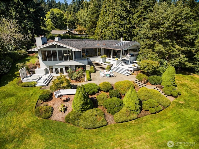 4802 E Mercer Way, Mercer Island, WA 98040 - rear view of house with a chimney, a deck, a wooded view, and a sunroom
