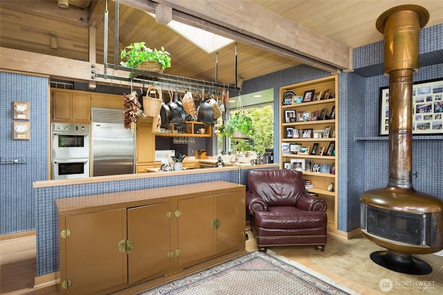 4802 E Mercer Way, Mercer Island, WA 98040 - kitchen with stainless steel built in refrigerator, wallpapered walls, double oven, a wood stove, and tile patterned floors