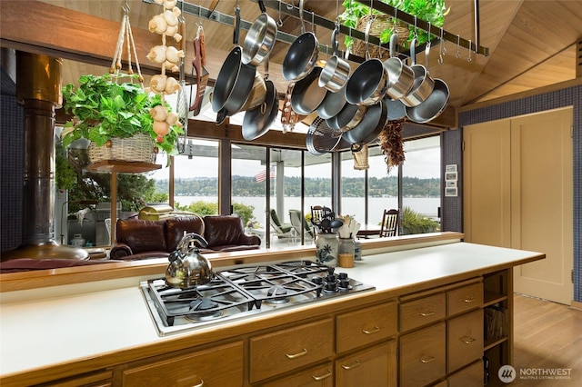 4802 E Mercer Way, Mercer Island, WA 98040 - kitchen with stainless steel gas stovetop, light wood-style flooring, light countertops, brown cabinetry, and lofted ceiling