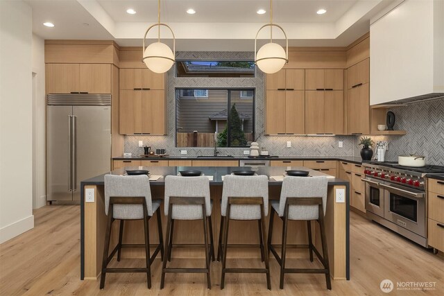 11618 NE 111th St, Kirkland, WA 98033 - kitchen with high quality appliances, light brown cabinetry, modern cabinets, a breakfast bar area, and recessed lighting