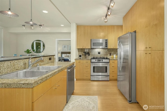 17 W Mercer St Unit 212, Seattle, WA 98119 - kitchen with stainless steel appliances, light brown cabinetry, light wood-style flooring, track lighting, and tasteful backsplash