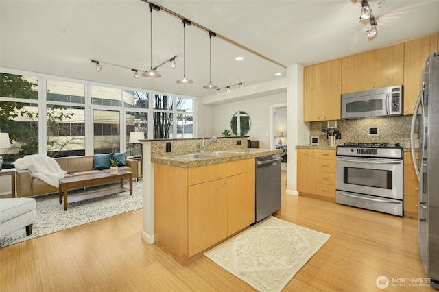 17 W Mercer St Unit 212, Seattle, WA 98119 - kitchen with stainless steel appliances, rail lighting, open floor plan, and light brown cabinetry