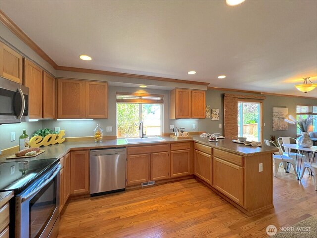26504 126th Pl SE, Kent, WA 98030 - kitchen with stainless steel appliances, ornamental molding, a peninsula, light wood-style floors, and plenty of natural light