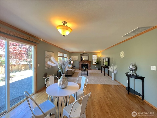 26504 126th Pl SE, Kent, WA 98030 - dining space featuring ornamental molding, light wood-style floors, and a fireplace