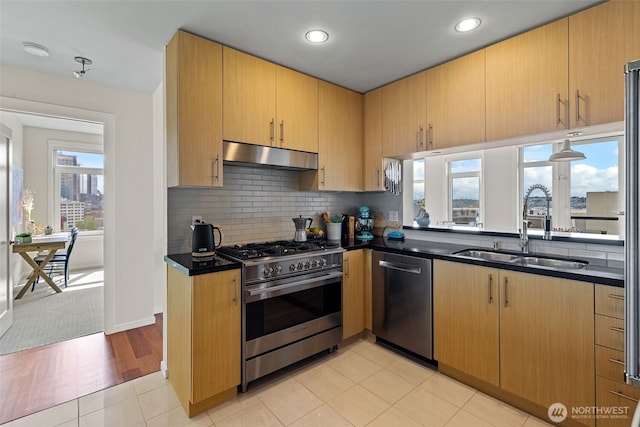 2721 1st Ave Unit 1101, Seattle, WA 98121 - kitchen with appliances with stainless steel finishes, dark countertops, under cabinet range hood, decorative backsplash, and recessed lighting