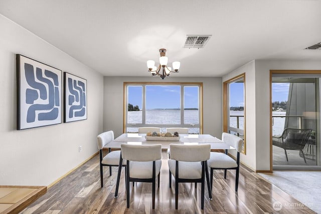 9727 NE Juanita Dr Unit 308, Kirkland, WA 98034 - dining space with a chandelier, plenty of natural light, wood finished floors, and a water view