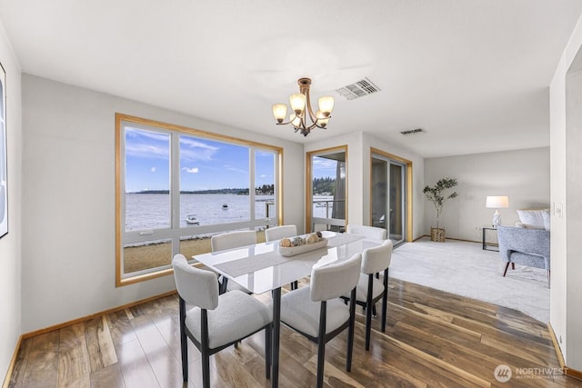 9727 NE Juanita Dr Unit 308, Kirkland, WA 98034 - dining room with a chandelier, wood finished floors, and a water view