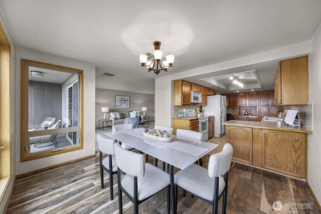 9727 NE Juanita Dr Unit 308, Kirkland, WA 98034 - dining space featuring a tray ceiling, a chandelier, and wood finished floors