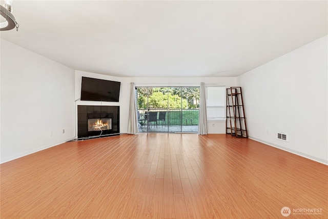 6405 Sand Point Way NE, Seattle, WA 98115 - unfurnished living room with wood finished floors and a tile fireplace