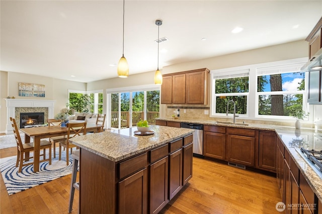 1501 209th Ave NE, Sammamish, WA 98074 - kitchen with dishwasher, light wood-style floors, hanging light fixtures, light stone countertops, and decorative backsplash