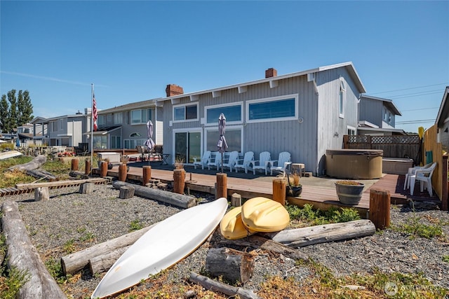 4421 Sucia Dr, Ferndale, WA 98248 - rear view of house with a chimney, a wooden deck, and a hot tub
