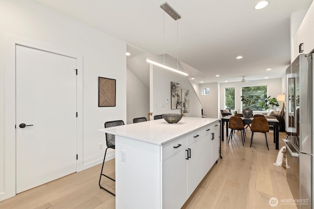 1323 N 185th St Unit A, Shoreline, WA 98133 - kitchen with high end fridge, light wood-style floors, a kitchen island, white cabinetry, and recessed lighting