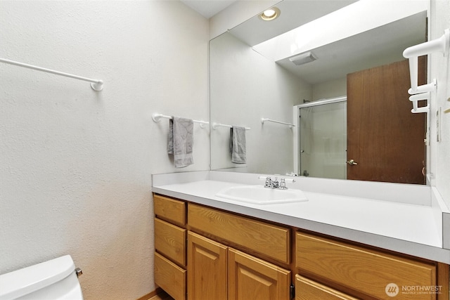 2417 179th Ave E, Lake Tapps, WA 98391 - bathroom featuring vanity, a shower with door, a textured wall, and recessed lighting