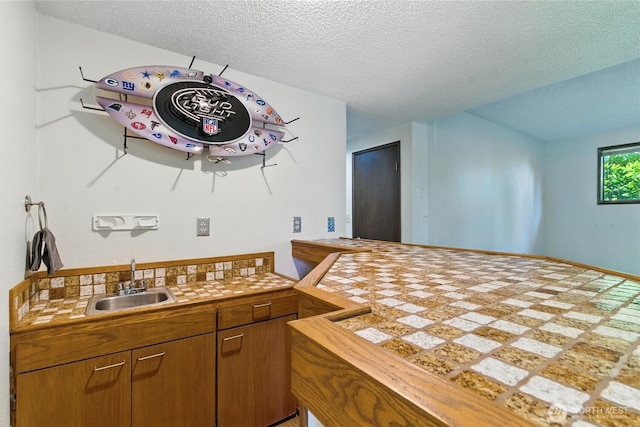 2417 179th Ave E, Lake Tapps, WA 98391 - kitchen featuring a textured ceiling, tile counters, brown cabinetry, and a peninsula