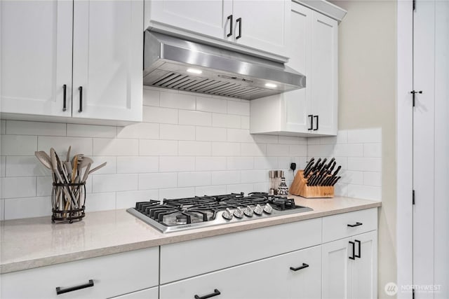 1118 26th St NW, Puyallup, WA 98373 - kitchen with under cabinet range hood, stainless steel gas cooktop, backsplash, and white cabinets