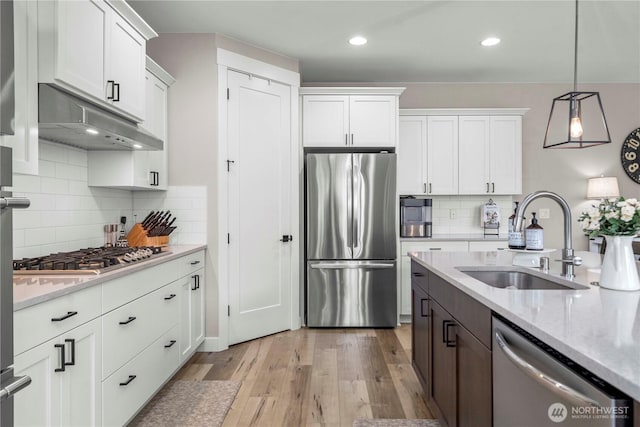 1118 26th St NW, Puyallup, WA 98373 - kitchen featuring stainless steel appliances, under cabinet range hood, white cabinetry, light wood-style flooring, and recessed lighting