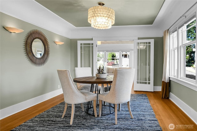 2456 4th Ave W, Seattle, WA 98119 - dining space featuring a chandelier, wood finished floors, and a tray ceiling