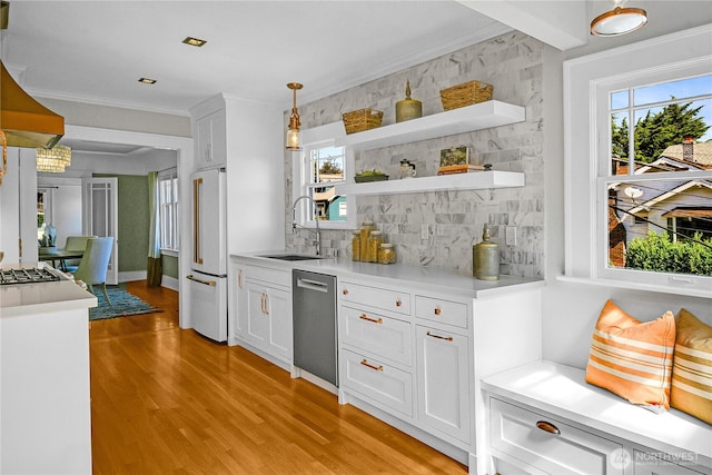 2456 4th Ave W, Seattle, WA 98119 - kitchen featuring dishwasher, white built in refrigerator, light wood finished floors, white cabinetry, and light countertops