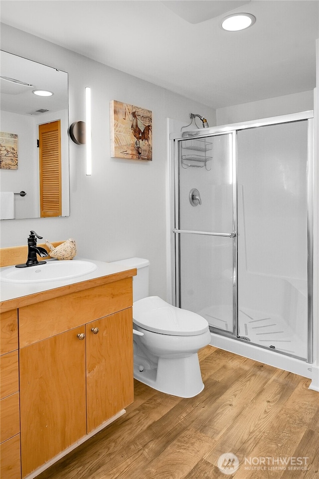 2456 4th Ave W, Seattle, WA 98119 - bathroom featuring vanity, a stall shower, and wood finished floors