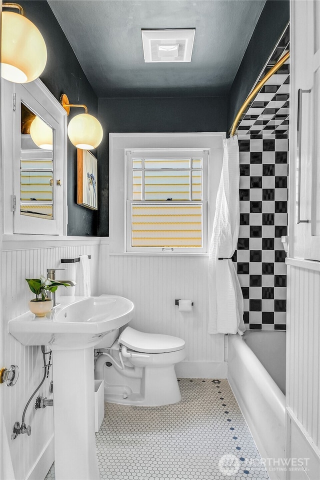 2456 4th Ave W, Seattle, WA 98119 - bathroom featuring wainscoting and shower / tub combo with curtain