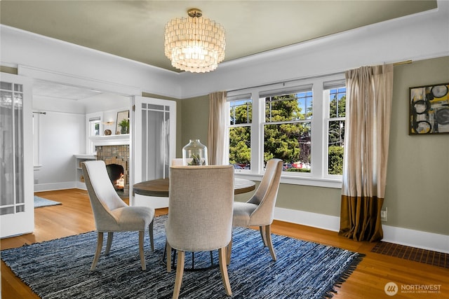 2456 4th Ave W, Seattle, WA 98119 - dining area featuring a chandelier, wood finished floors, and a fireplace