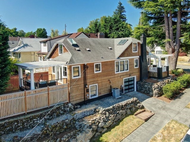 2456 4th Ave W, Seattle, WA 98119 - back of property with a chimney, a pergola, a garage, and a shingled roof