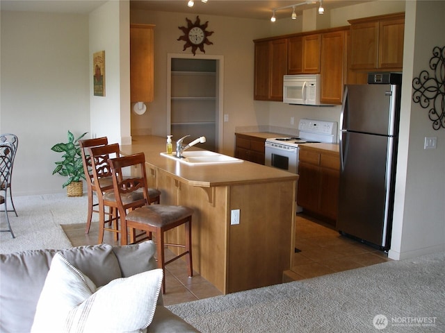 1601 Maiden Ln Unit B104, Wenatchee, WA 98801 - kitchen with white appliances, a kitchen bar, a peninsula, and light colored carpet