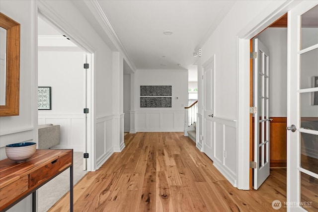19735 183rd Way SE, Renton, WA 98058 - corridor with light wood-style floors, crown molding, stairs, a wainscoted wall, and a decorative wall
