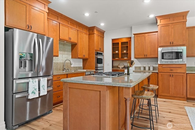 19735 183rd Way SE, Renton, WA 98058 - kitchen featuring stainless steel appliances, light wood-type flooring, a breakfast bar, a kitchen island, and recessed lighting