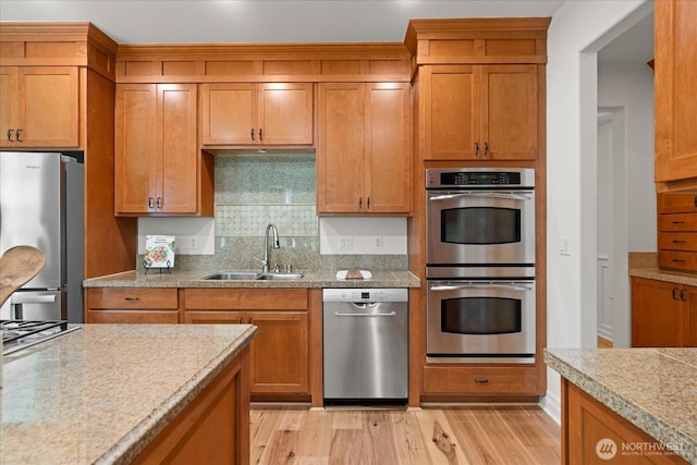19735 183rd Way SE, Renton, WA 98058 - kitchen featuring appliances with stainless steel finishes, light wood-style floors, decorative backsplash, and brown cabinets