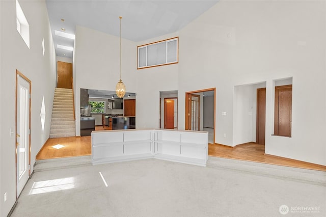 5225 Illahee Ln NE, Olympia, WA 98516 - unfurnished living room with a high ceiling, stairway, and light colored carpet