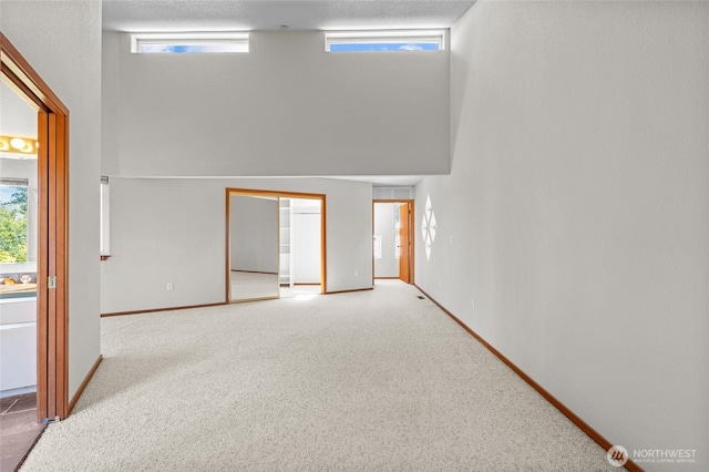 5225 Illahee Ln NE, Olympia, WA 98516 - carpeted empty room featuring baseboards and a high ceiling