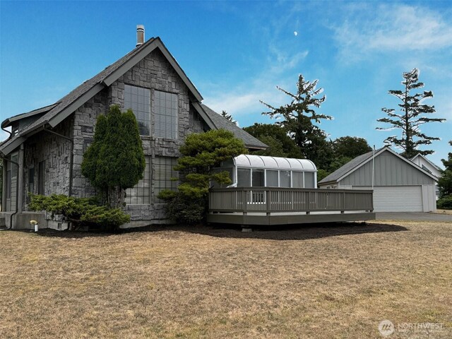 598 Blue Wing Loop SE, Ocean Shores, WA 98569 - view of side of property with an outbuilding, stone siding, a garage, and a lawn