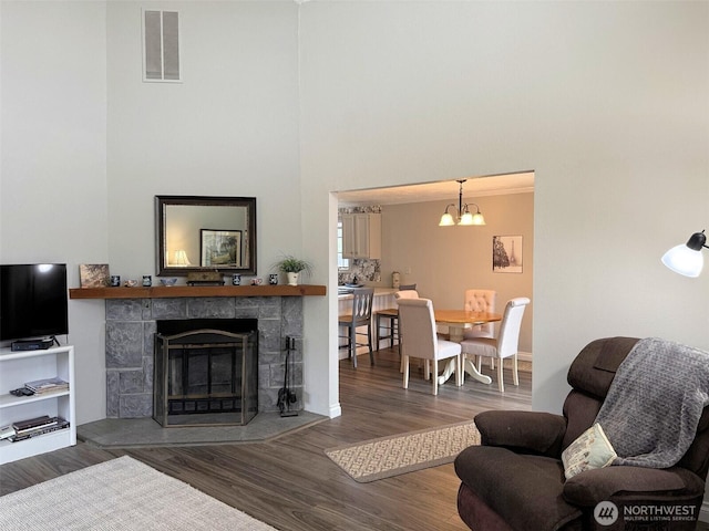 598 Blue Wing Loop SE, Ocean Shores, WA 98569 - living area featuring a stone fireplace, wood finished floors, a chandelier, and a towering ceiling