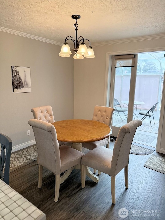 598 Blue Wing Loop SE, Ocean Shores, WA 98569 - dining area featuring a chandelier, dark wood-type flooring, a textured ceiling, and ornamental molding