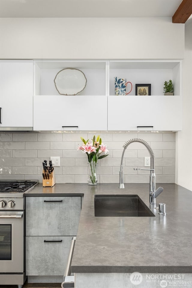917 NW 51st St Unit D, Seattle, WA 98107 - kitchen with stainless steel gas range oven, white cabinets, tasteful backsplash, dark countertops, and open shelves
