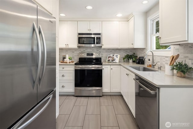 3033 48th Ave SW, Seattle, WA 98116 - kitchen featuring stainless steel appliances, decorative backsplash, white cabinets, light countertops, and recessed lighting