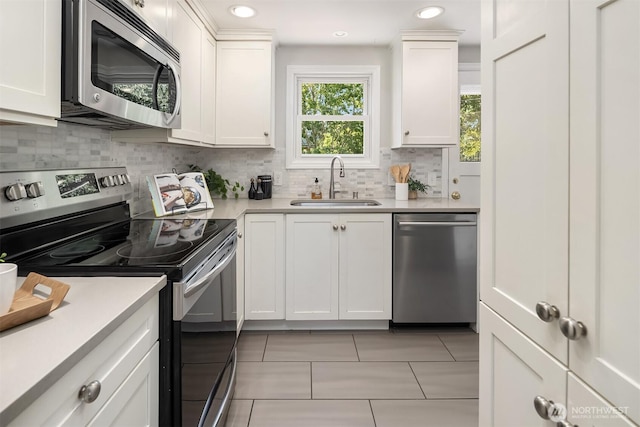 3033 48th Ave SW, Seattle, WA 98116 - kitchen featuring appliances with stainless steel finishes, white cabinets, decorative backsplash, light countertops, and recessed lighting