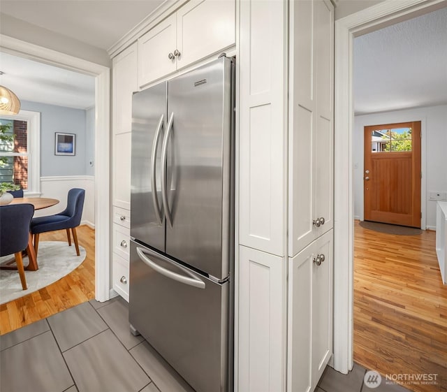 3033 48th Ave SW, Seattle, WA 98116 - kitchen with freestanding refrigerator, white cabinetry, and light wood-style floors