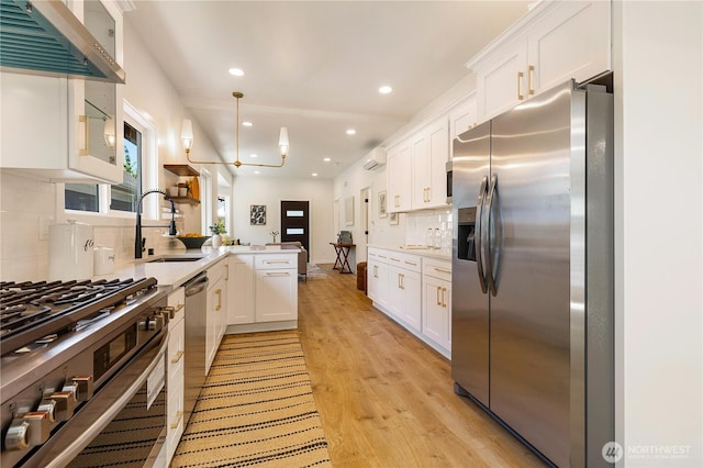 5310 46th Ave S, Seattle, WA 98118 - kitchen featuring stainless steel appliances, a peninsula, range hood, white cabinetry, and recessed lighting