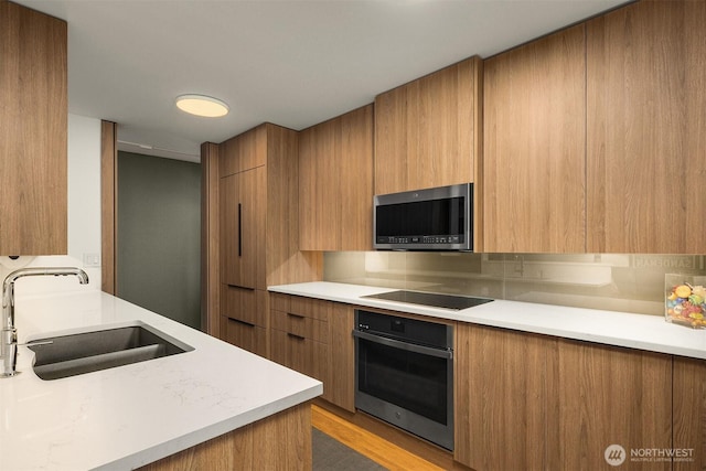 3650 26th Pl W Unit 202A, Seattle, WA 98199 - kitchen featuring modern cabinets, appliances with stainless steel finishes, light countertops, and brown cabinets