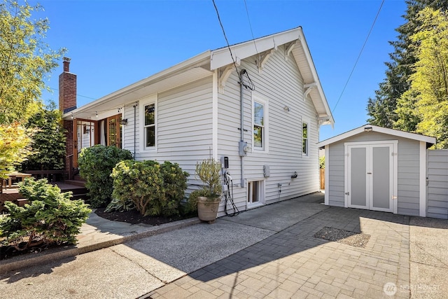 5817 28th Ave NW, Seattle, WA 98107 - view of home's exterior with a storage shed, a patio, and a chimney