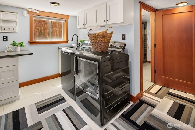 5817 28th Ave NW, Seattle, WA 98107 - washroom featuring washer and clothes dryer, cabinet space, and light tile patterned floors